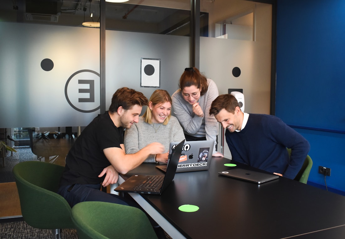 Colleagues discussing work together around a laptop
